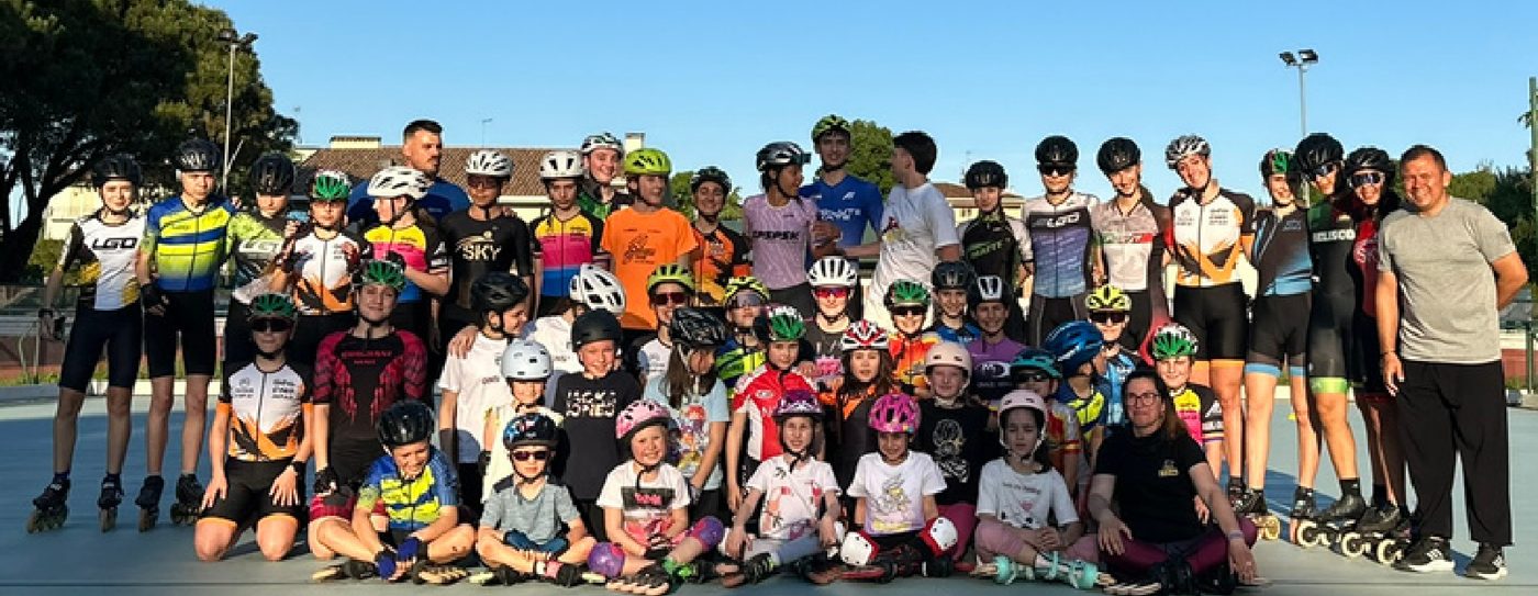 Large club group of young and adult skaters with the coach